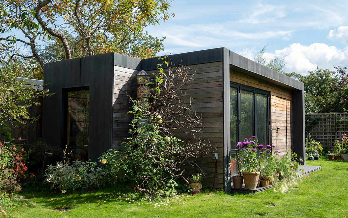 A garden room surrounded by plants and trees on a sunny day
